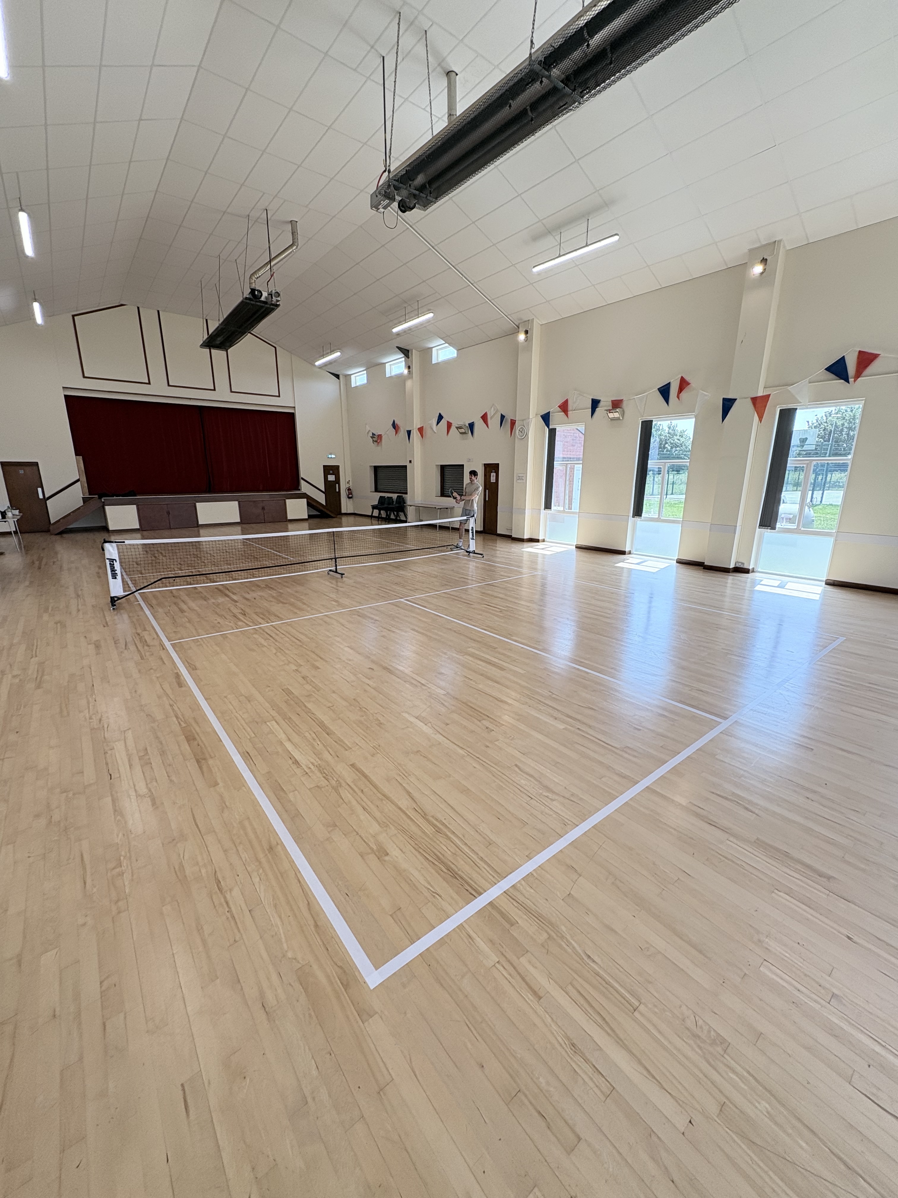 Taped pickleball court lines in a village hall — Suffolk Pickleball Co.